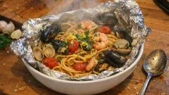 Spaghetti al cartoccio ai frutti di mare: profumati e scenografici, pronti in forno