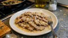 Straccetti di vitello morbidi in padella: il trucco della farina per una cremina leggera